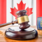 A Gavel And A Law Book in front of Canadian flag
