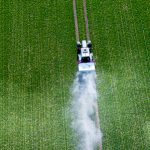 Three Tractors Spray Pesticides On A Green Field Top View
