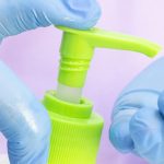 Dispenser With Disinfectant. Gloved Hands. Use Of A Disinfectant